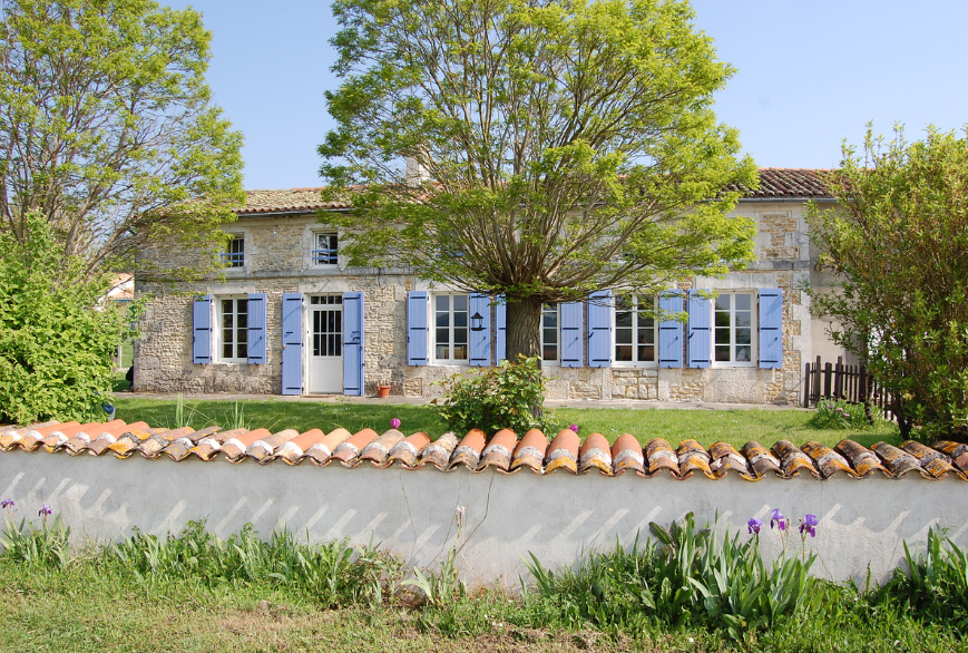 Façade de maison en pierre avec volets battants bleus Vue d'ici, une alternative isolante aux volets en bois et aluminium.